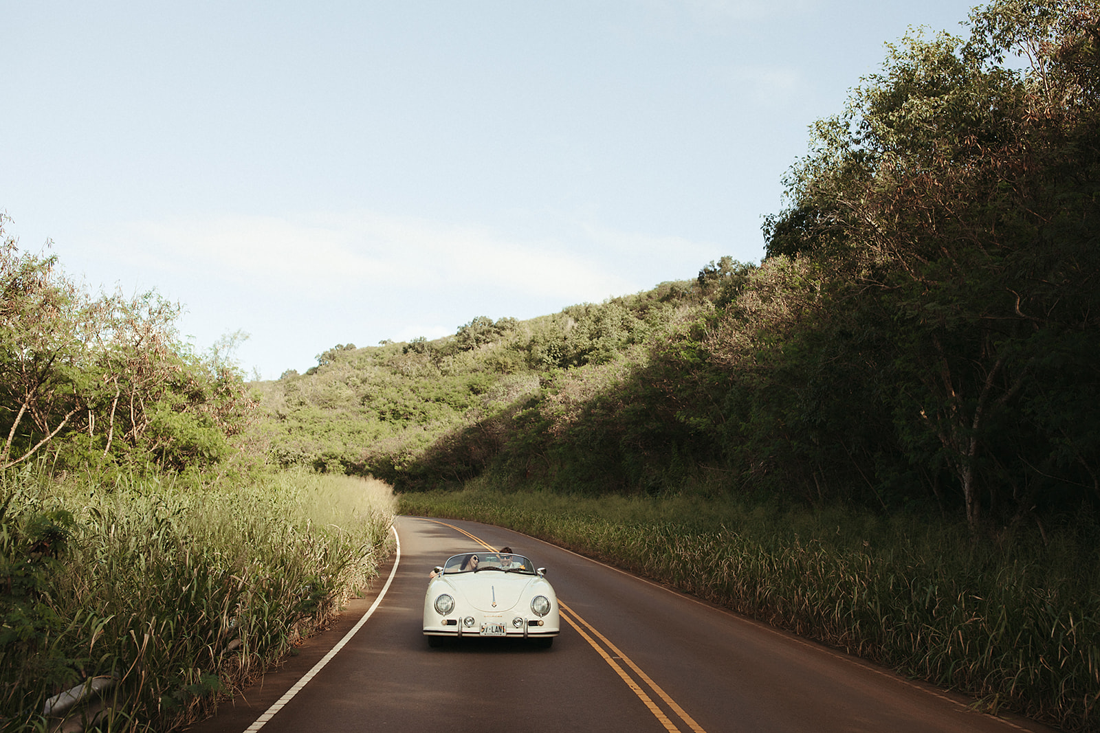 bride and groom portrait driving down maui highway in a classic car